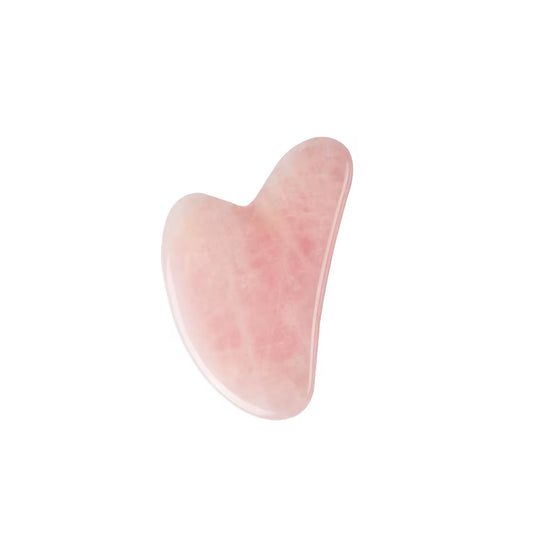 Rose quartz gua sha facial tool on cream surface
